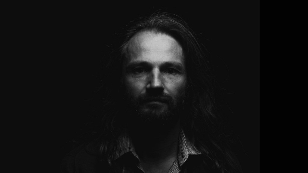 Homem de frente no escuro