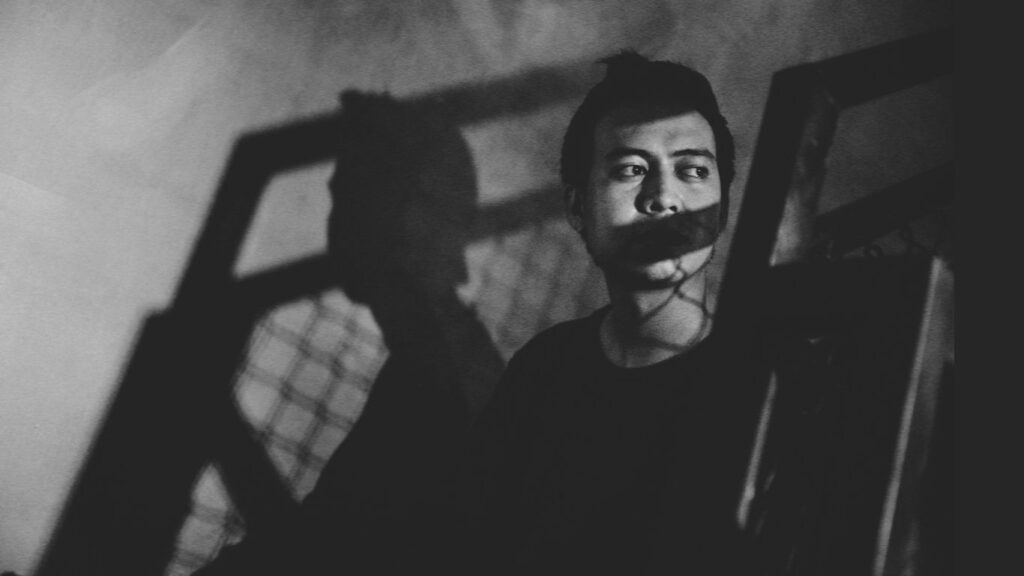 homem em sombra preto e branco refletindo insegurança e excesso de fala